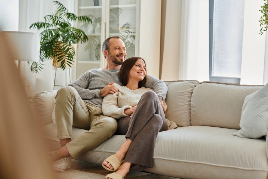 joyful,child free,couple,relaxing,on,cozy,sofa,in,living,room